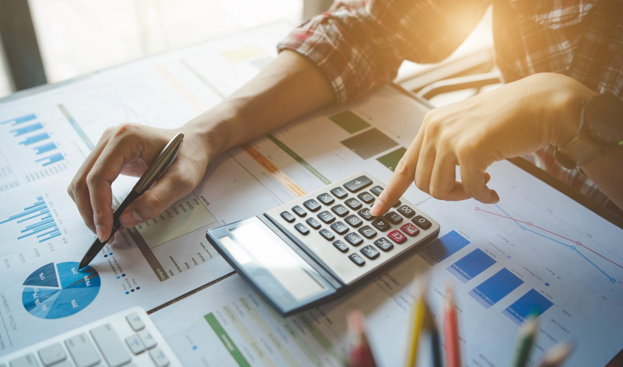 Businessman working on calculator to calculate business data the financial report. Business financial analysis and strategy concept.
